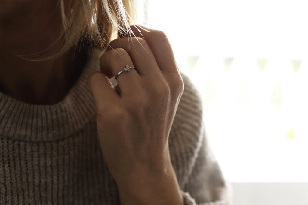 Close-up of a person wearing a ring with a blurred background