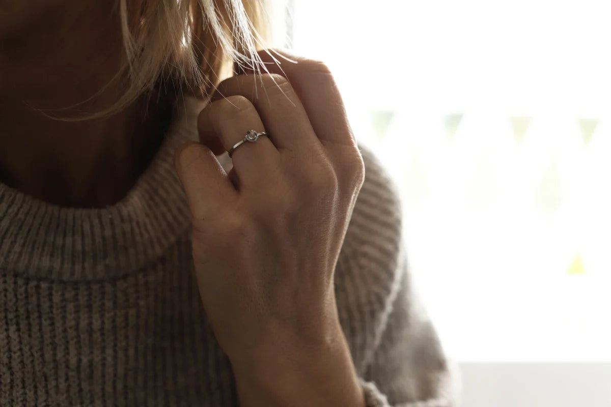 Close-up of a person wearing a ring with a blurred background