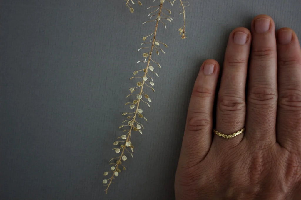 delicate gold wishbone ring worn alone on hand laurel carving detail