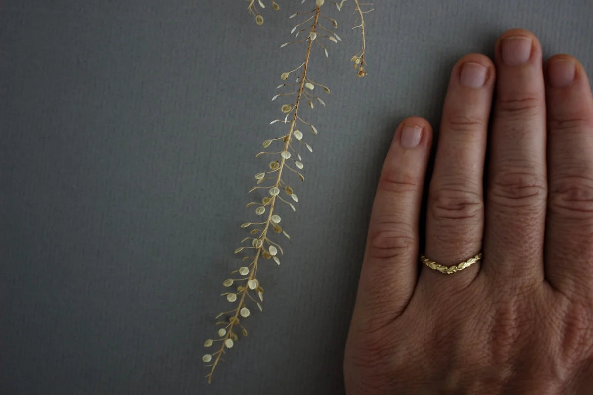 delicate gold wishbone ring worn alone on hand laurel carving detail